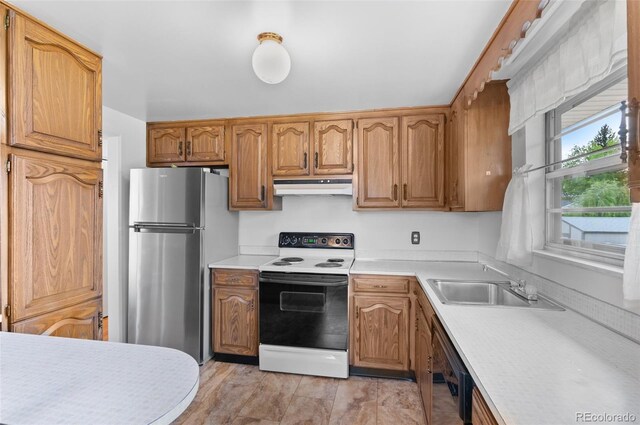 kitchen featuring white range with electric cooktop, under cabinet range hood, freestanding refrigerator, a sink, and black dishwasher