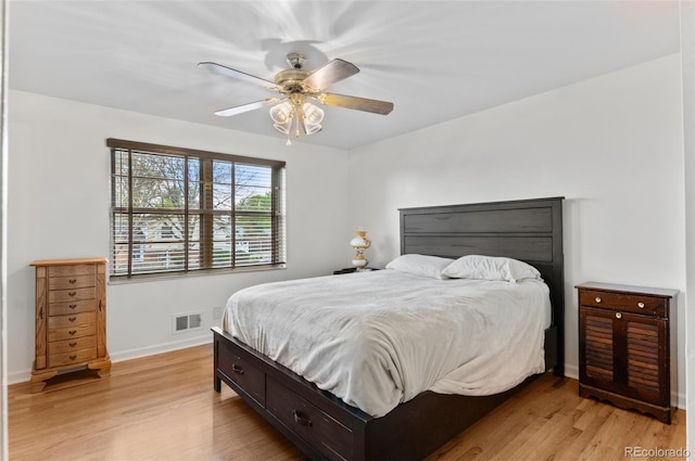 bedroom with light wood-style floors, baseboards, and ceiling fan