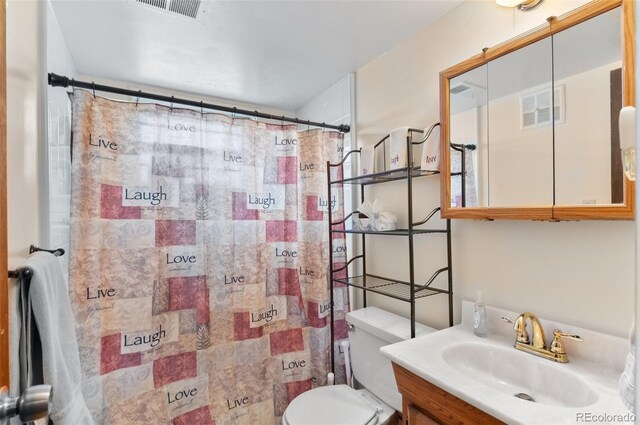 bathroom featuring toilet, vanity, and a shower with curtain