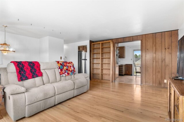 living room with light wood finished floors and wooden walls