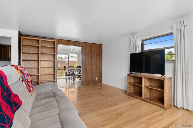 living room featuring light wood finished floors and wooden walls