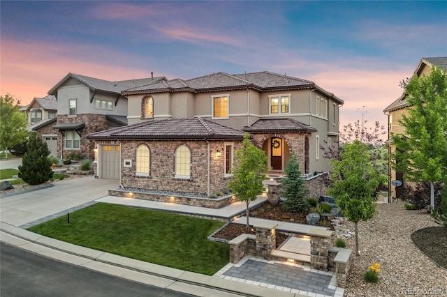 10757 Timberdash Ave, Highlands Ranch, CO 80126 - mediterranean / spanish-style home featuring concrete driveway, stucco siding, stone siding, a tiled roof, and a lawn
