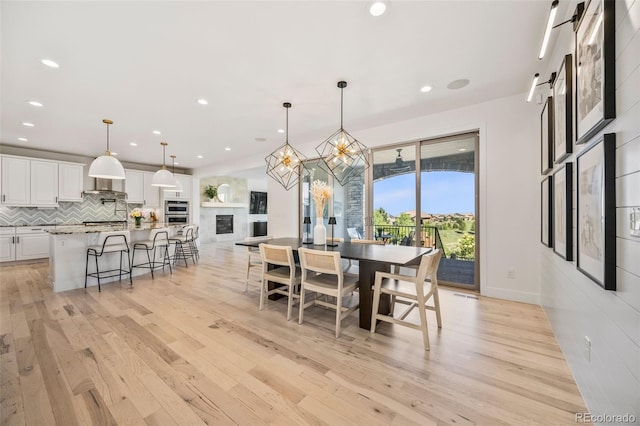 10757 Timberdash Ave, Highlands Ranch, CO 80126 - dining room with light wood-type flooring, recessed lighting, and a glass covered fireplace