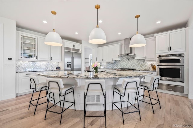 10757 Timberdash Ave, Highlands Ranch, CO 80126 - kitchen with appliances with stainless steel finishes, a warming drawer, wall chimney exhaust hood, backsplash, and white cabinetry