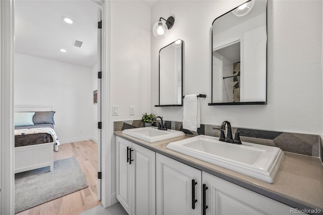 10757 Timberdash Ave, Highlands Ranch, CO 80126 - ensuite bathroom featuring double vanity, wood finished floors, and recessed lighting