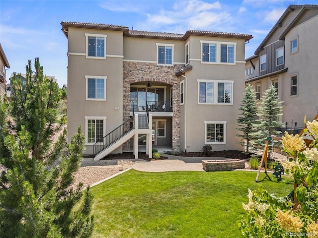 10757 Timberdash Ave, Highlands Ranch, CO 80126 - back of house with stone siding, a ceiling fan, a lawn, and stucco siding