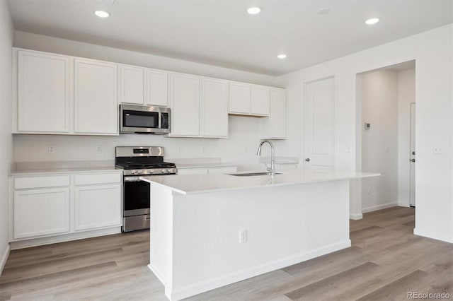 24790 E 39th Ave, Aurora, CO 80019 - kitchen featuring appliances with stainless steel finishes, a sink, light wood finished floors, white cabinetry, and recessed lighting