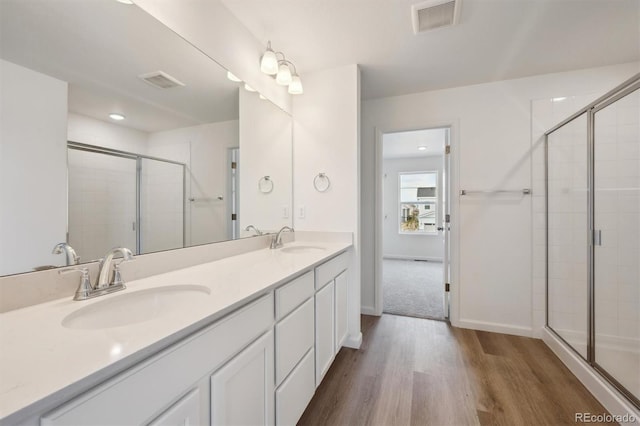 24790 E 39th Ave, Aurora, CO 80019 - bathroom featuring wood finished floors, a stall shower, double vanity, and baseboards