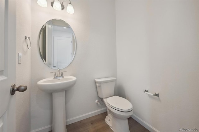 24790 E 39th Ave, Aurora, CO 80019 - bathroom with wood finished floors, toilet, baseboards, and a sink