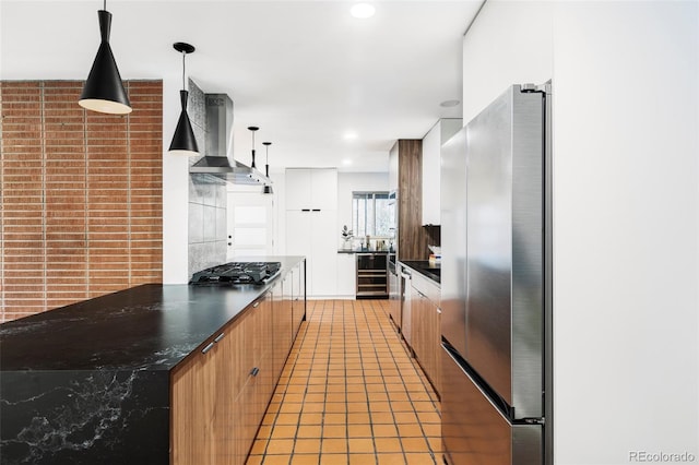 1330 Olive St, Denver, CO 80220 - kitchen with wall chimney exhaust hood, dark countertops, modern cabinets, black gas stovetop, and freestanding refrigerator