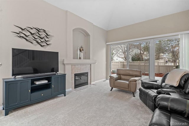 living area featuring light colored carpet, baseboards, high vaulted ceiling, and a tiled fireplace