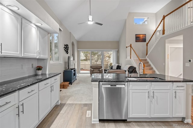 kitchen with light wood-style flooring, a sink, open floor plan, stainless steel dishwasher, and ceiling fan