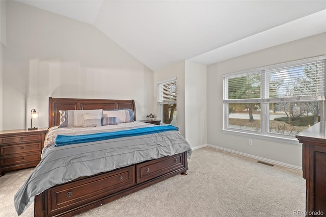 bedroom featuring light colored carpet, visible vents, baseboards, and lofted ceiling