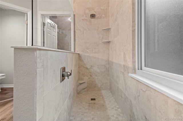bathroom with toilet and tiled shower