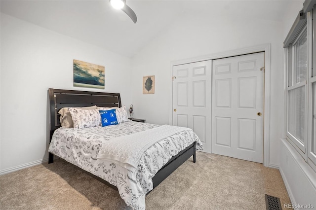bedroom with vaulted ceiling, ceiling fan, carpet, and a closet