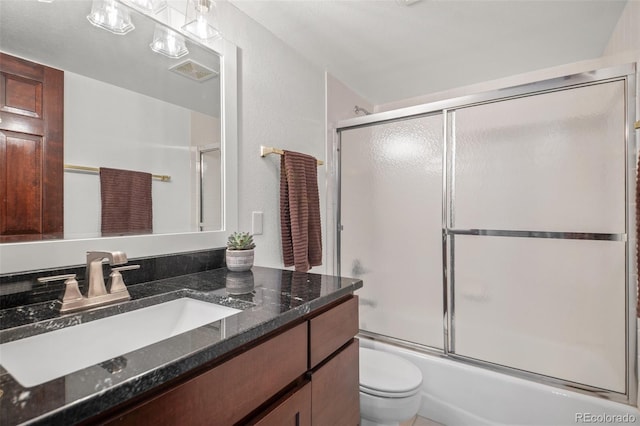 full bath with toilet, visible vents, vanity, and combined bath / shower with glass door