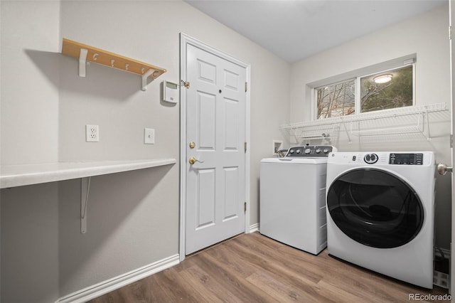 washroom featuring separate washer and dryer, laundry area, and wood finished floors
