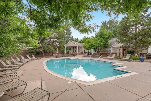 community pool featuring a patio and fence