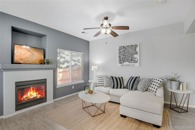 9080 Gale Blvd Unit 4, Thornton, CO 80260 - living room featuring wood finished floors, a ceiling fan, a glass covered fireplace, and baseboards