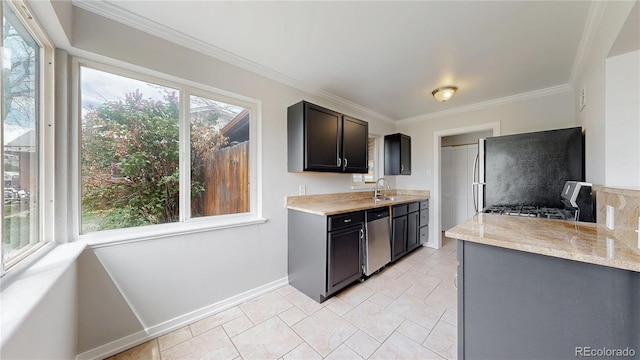 kitchen with stone finish floor, baseboards, ornamental molding, a sink, and stainless steel appliances