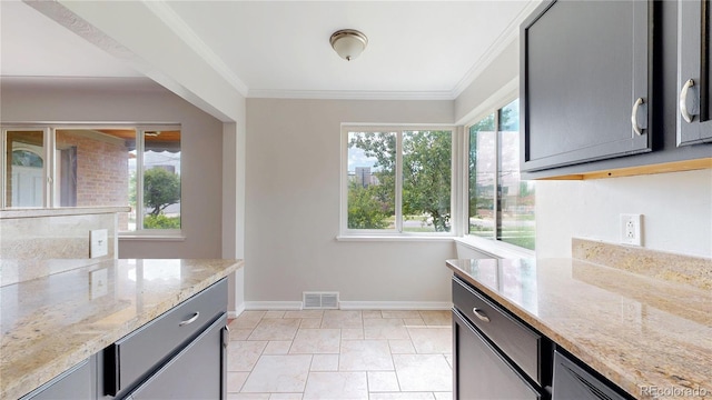 kitchen featuring baseboards, crown molding, light stone counters, gray cabinetry, and stone tile flooring