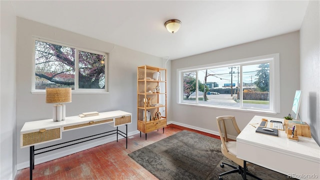 office featuring healthy amount of natural light, wood finished floors, and baseboards