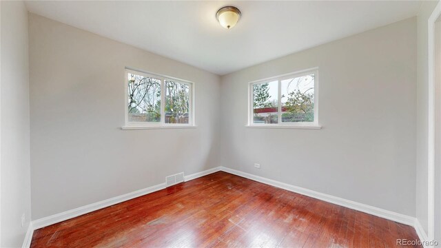 empty room with baseboards and wood finished floors