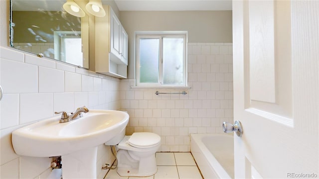 full bathroom with tile walls, toilet, a tub to relax in, tile patterned flooring, and a shower
