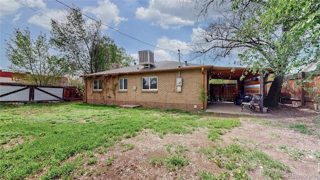 back of house with a yard, a patio area, a fenced backyard, and crawl space