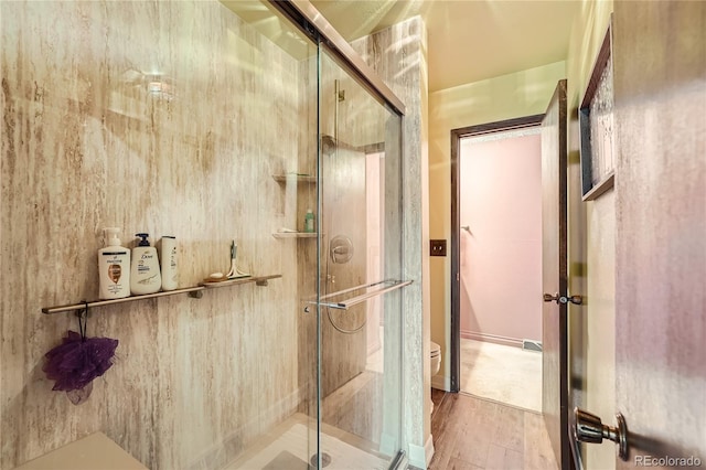 bathroom featuring toilet, an enclosed shower, and hardwood / wood-style floors