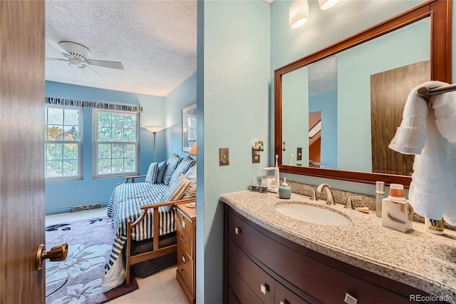 bathroom with vanity, ceiling fan, and a textured ceiling