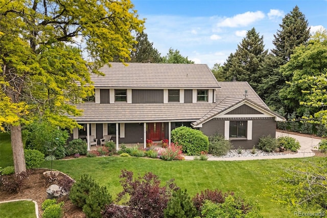 6128 S Coventry Ln E, Littleton, CO 80123 - traditional-style house with a front lawn, a porch, and a tiled roof