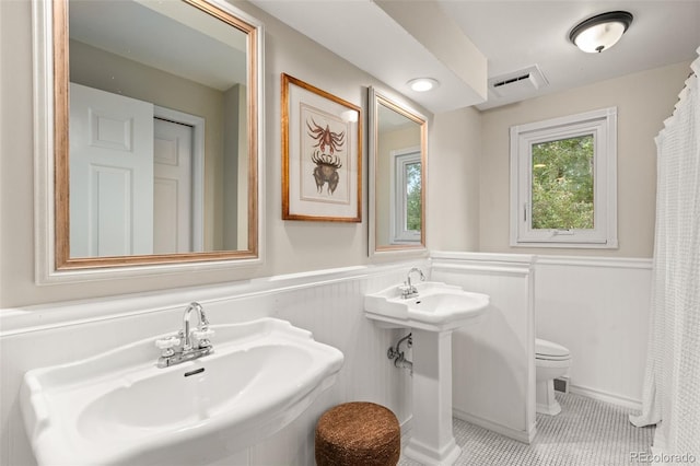 6128 S Coventry Ln E, Littleton, CO 80123 - full bathroom with toilet, a wainscoted wall, tile patterned floors, and a sink
