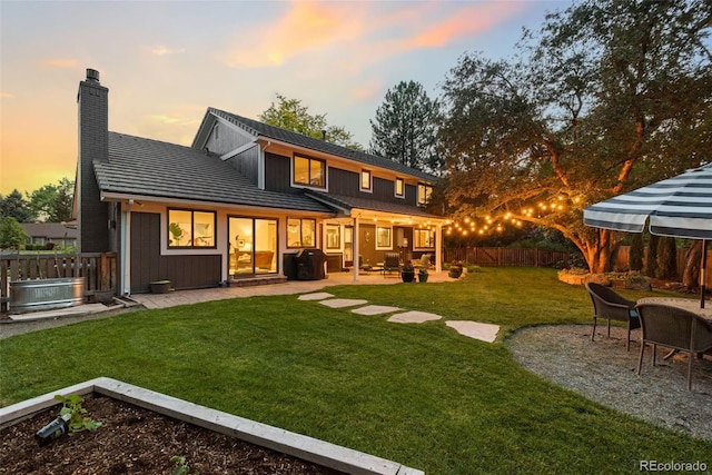 6128 S Coventry Ln E, Littleton, CO 80123 - back of house featuring a patio area, a chimney, and board and batten siding
