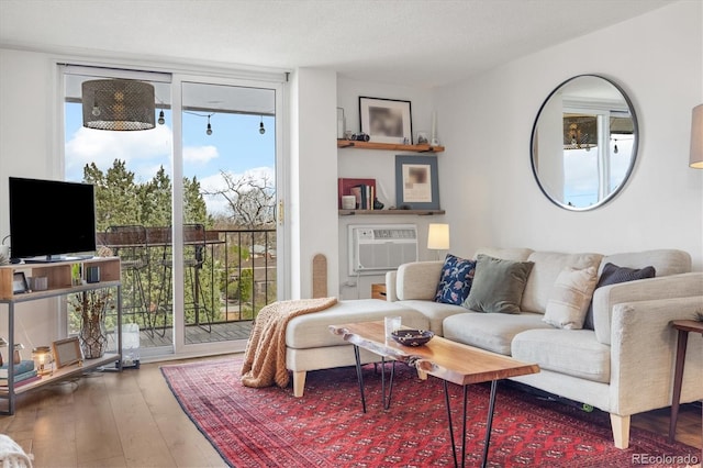 living room featuring an AC wall unit and hardwood / wood-style floors