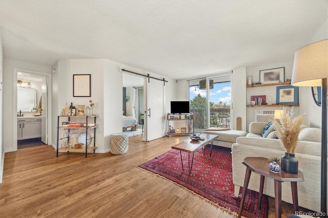 799 Dahlia St Unit 503, Denver, CO 80220 - living area with a textured ceiling, a barn door, and wood finished floors