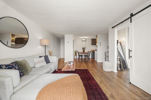 799 Dahlia St Unit 503, Denver, CO 80220 - living area featuring a textured ceiling, a barn door, and light wood-style flooring