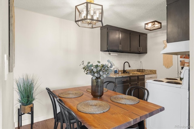 dining space featuring a textured ceiling, a chandelier, and wood finished floors