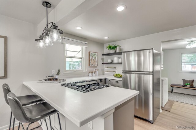 2845 Eaton St, Wheat Ridge, CO 80214 - kitchen featuring stainless steel appliances, open shelves, a peninsula, light wood-style flooring, and light countertops