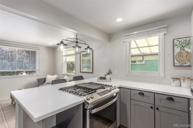 2845 Eaton St, Wheat Ridge, CO 80214 - kitchen with stainless steel gas range oven, gray cabinetry, a peninsula, recessed lighting, and healthy amount of natural light