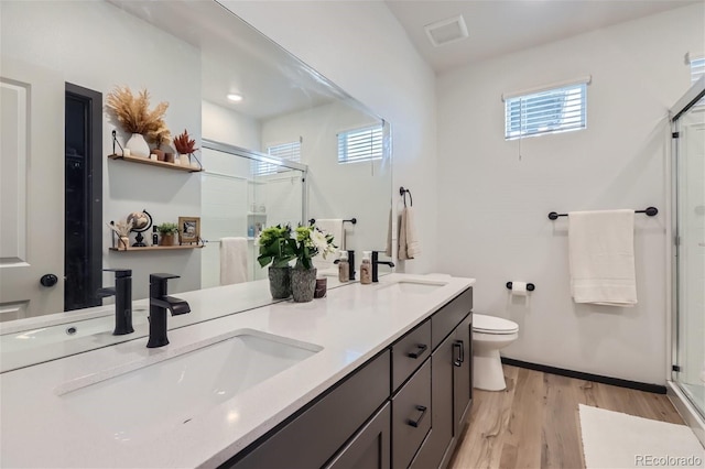 bathroom featuring toilet, wood-type flooring, walk in shower, and vanity