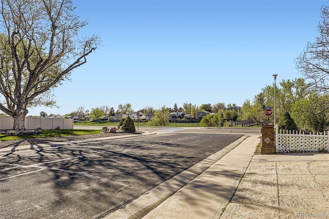 12425 Bellaire Dr, Thornton, CO 80241 - view of asphalt road with curbs, traffic signs, sidewalks, and street lighting