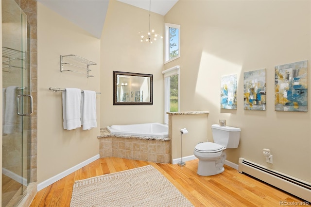 1952 Columbine Ct, Golden, CO 80401 - full bath featuring a baseboard radiator, wood finished floors, a shower stall, a chandelier, and a garden tub