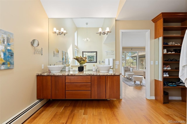 1952 Columbine Ct, Golden, CO 80401 - full bathroom with a baseboard heating unit, a chandelier, wood finished floors, double vanity, and a towering ceiling