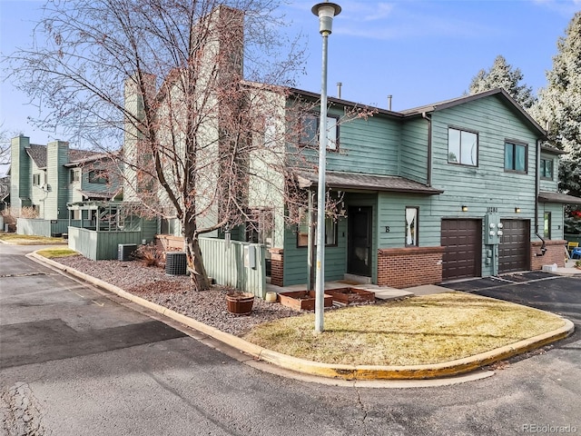 view of front of home with central air condition unit and a garage