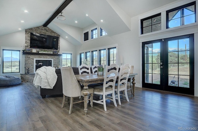 dining space featuring beam ceiling, high vaulted ceiling, a fireplace, and hardwood / wood-style floors