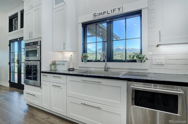 kitchen featuring white cabinets, sink, dark hardwood / wood-style flooring, and a healthy amount of sunlight