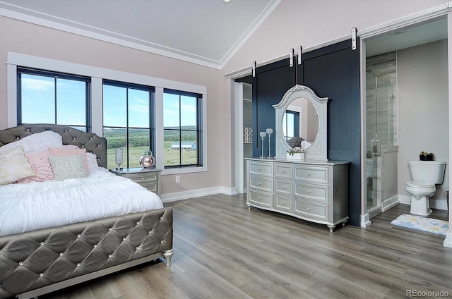 bedroom featuring wood-type flooring, vaulted ceiling, a barn door, and ornamental molding