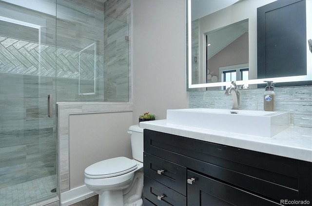 bathroom featuring lofted ceiling, toilet, vanity, and a shower with shower door