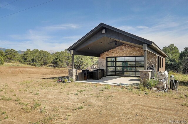 back of property with ceiling fan and a patio area